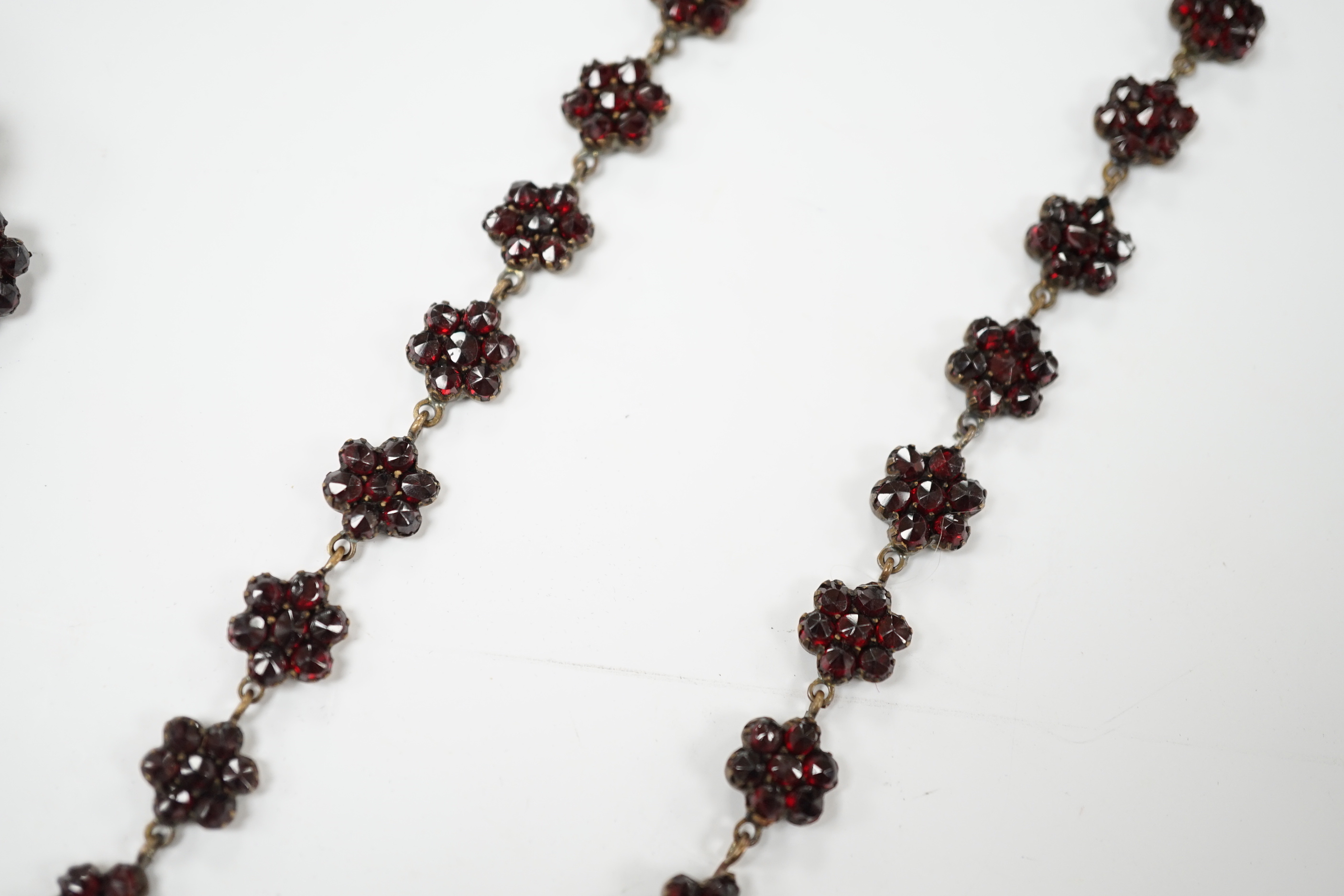 A Victorian garnet set gilt metal and tortoiseshell suite of jewellery comprising bracelet, necklace, ring and two hair combs